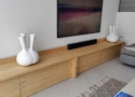 Het tv-meubel met kleppen is gemaakt van eikenhout en het is ook mogelijk om het tv meubel om te vormen tot bank, simpelweg door het toevoegen van op maat gemaakte kussens.